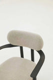 Close-up of a chair with beige cushioned backrest and seat on a white background