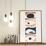 Contemporary abstract canvas art featuring stylized eyes in a geometric pattern, set in a home office alongside modern decor and lighting.