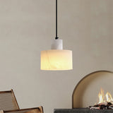 Single alabaster-effect pendant light glowing warmly above a fireplace, ideal for cosy modern interiors with natural textures and earthy tones.