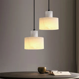 Two pendant lights hanging above a table with a minimal background