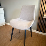 White chair with black legs on a wooden floor