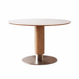 White round dining table with oak-look pedestal base in a bright contemporary dining room