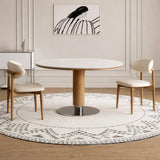 Round white dining table for 2 with wood finish pedestal in a minimalist interior