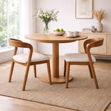 Round dining table with two Scandinavian dining chairs in a bright UK home