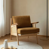 Brown armchair with wooden frame in a minimalistic room.