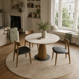 Round dining table with ceramic top and wood pedestal base in a bright neutral interior, ideal for searches such as mid-century dining table, 100cm dining table and 120cm dining table
