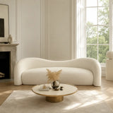 Gilla Sofa styled in a neutral living room, showing a luxury minimalist sofa with curved arms, soft white upholstery, and a modern designer look ideal for contemporary home interiors