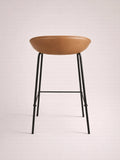 Bar stool with brown seat and black metal legs on a light background