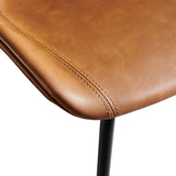 Close-up of the Hackney Industrial Leather Bar Stool seat, featuring smooth saddle-brown leather with precision stitching and a comfortable curved edge, supported by a sturdy black metal frame.