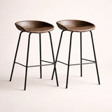 Two brown bar stools with black metal legs on a light background