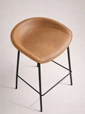 Brown leather bar stool with black metal legs on a light gray background