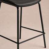 Black bar stool with a beige background