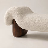 Close-up of the Haven boucle upholstered bench with curved cream fabric and dark walnut-style wooden leg