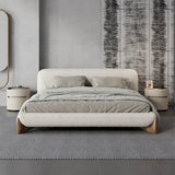Modern bedroom with a gray upholstered bed and matching nightstands.
