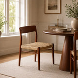 Wooden chair with woven seat in a cozy dining room setting.