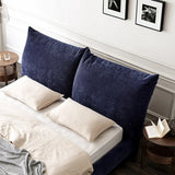 Sophisticated bedroom showcasing a deep blue velvet bedframe against a crisp white wall,