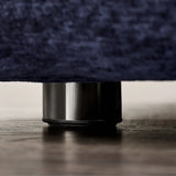 Close-up of a sturdy metallic leg of a navy blue bedframe, highlighting the detailed texture and quality craftsmanship.