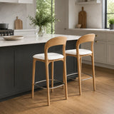 Pair of mid-century bar stools with oak wood frames and white seats styled at a modern kitchen island