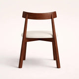Wooden chair with a white cushion on a light background