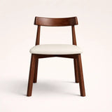 Wooden chair with a white cushion on a light beige background