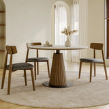 Dining area with a round table and four chairs in a well-lit room.
