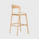 Front view of a raw wood bar stool with ash wood frame and cushioned white seat, combining mid-century bar stool style with clean lines for stylish home bar seating.