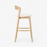Side view of an ash wood bar stool with a raw wood finish, upholstered seat and minimalist frame, offering a modern alternative to a walnut bar stool or metal bar stool.