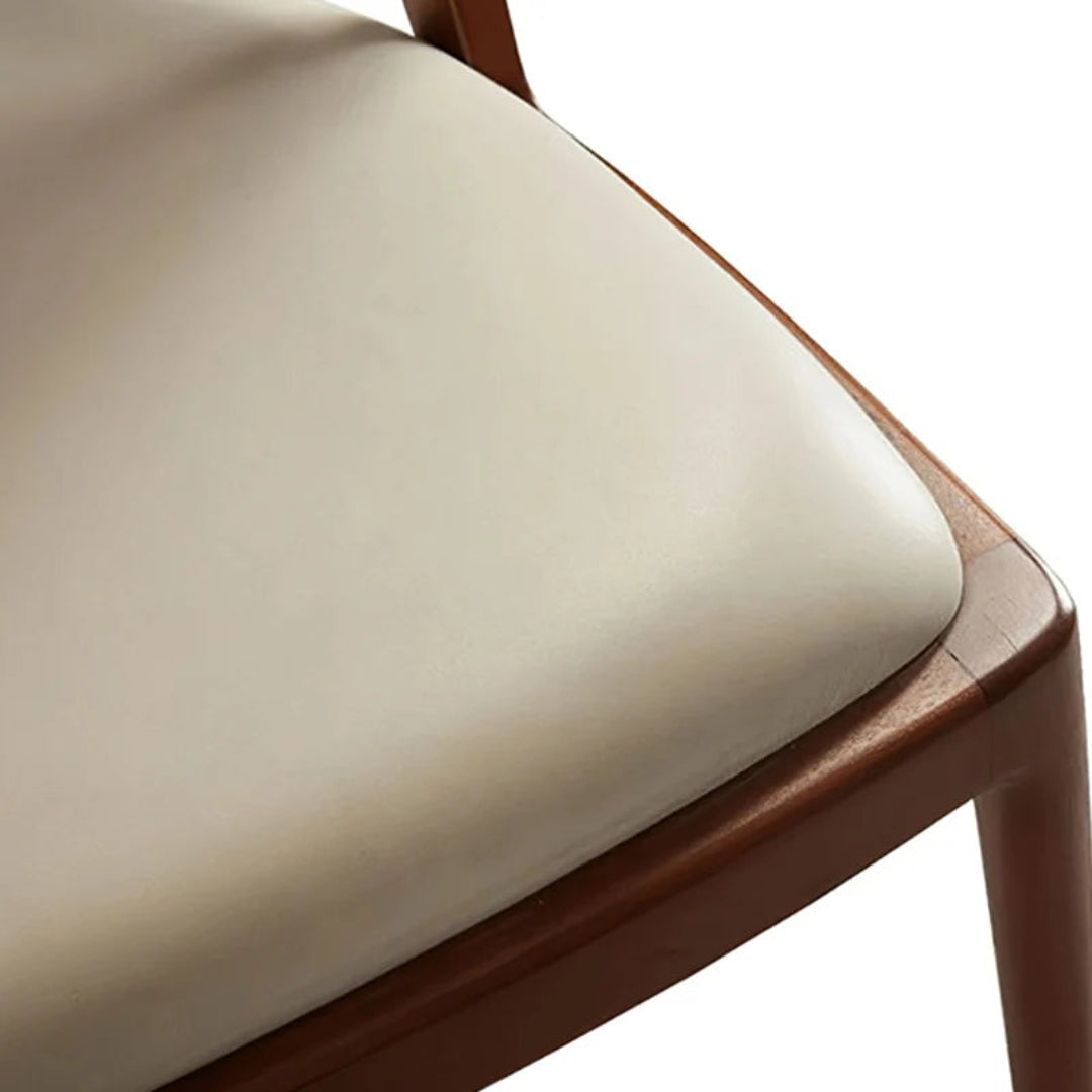Close-up of the cream upholstered seat and light walnut-finished ash wood frame on the Twickenham dining chair