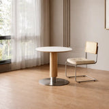 Modern round dining table with white tabletop and wood pedestal base for small spaces