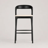 Black bar stool with a white seat on a light gray background