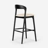 Black bar stool with a white cushioned seat on a light gray background