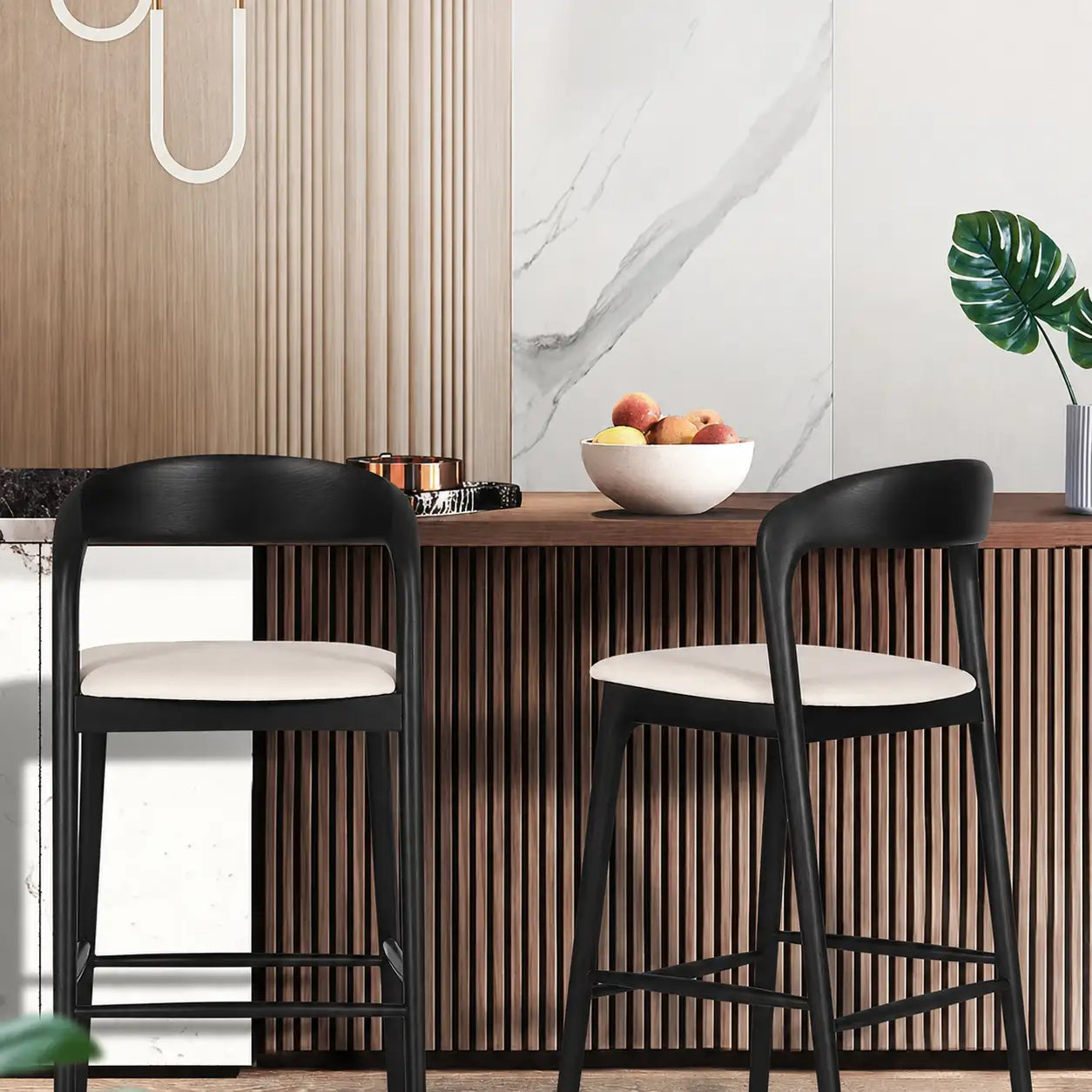 Two black bar stools with white seats in front of a wooden bar counter.
