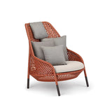 Elegant rattan lounge chair in warm terracotta, featuring a woven design and soft beige cushions with complementary gray pillows, perfect for adding comfort and style to your outdoor or indoor seating area.