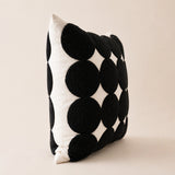 Side view of the Polka Dot Tufted Cushion showing raised black tufted circles on a natural cotton base