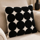 Black and natural Polka Dot Tufted Cushion styled on a neutral textured sofa