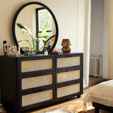 The Qienn Rattan Six Chest-of-Drawers in a modern bedroom setting, paired with a round mirror and decor accessories.