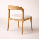 Wooden chair with a white cushion on a light background