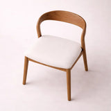 Walnut dining chair with curved backrest and upholstered seat at 45 degree angle