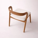 Rear view of modern dining chair with curved wooden frame and soft seat
