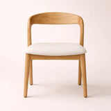 Wooden chair with white cushion on a light background