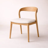 Wooden chair with a white cushion on a light background