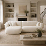 Front view of the white Tofu sofa in a refined UK home interior with fireplace, framed wall art, marble coffee table and neutral palette.