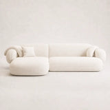 White Tofu sofa shown in a clean studio setting with a minimalist backdrop, highlighting its sculptural curved silhouette and deep seat.