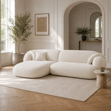 White Tofu sofa in a contemporary open-plan UK home with marble coffee table, soft neutral rug, indoor greenery and minimalist kitchen backdrop.