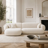 Modern living room with a white sofa, wooden coffee table, and decorative elements.