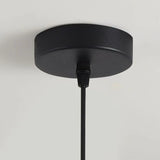 Close-up of a black ceiling cap of a pendant light, featuring a simple design with a fine-textured finish and a black cord adjustment mechanism.