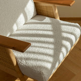 Wooden chair with a textured white cushion on a wooden floor