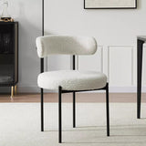 Chic white boucle dining chair with a cylindrical backrest and black metal frame, set in a modern, light-filled dining room with soft neutral tones.