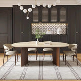 Elegant mid-century dining room with Benenden Solid Ash Dining Chairs and oval travertine table, styled in a modern British kitchen with dark cabinetry and statement lighting.