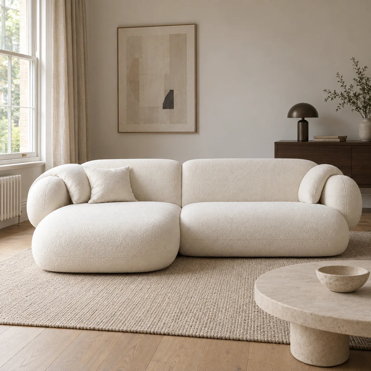 Cream modular chaise sofa in a softly lit British living room with oak flooring and walnut furniture